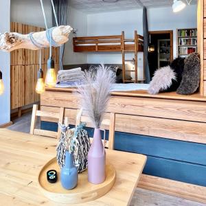 ロストックにあるSURFKAJÜTE - Ferienwohnung in Warnemündeのテーブルの上に2つの花瓶が置かれたベッドのある部屋