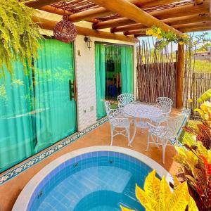 佩德拉斯港BANGATACHO - Bangalôs Temáticos na Praia do Patacho - Rota Ecológica dos Milagres的庭院配有桌椅、桌子和椅子。