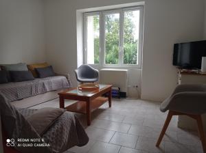 a living room with a couch and a table at Repos au bord de l'eau in Nyoiseau