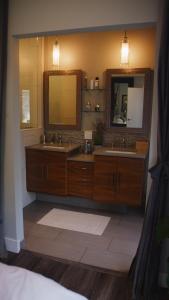 une salle de bain avec deux lavabos et un grand miroir dans l'établissement Boutique Villa with hot tub, à Broadmoor