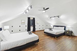 two beds in a room with wooden floors at Russwood Acres Estate ft Gym Cinema Pool Table in Rockhill +44 photos