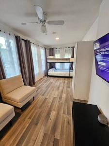 a living room with a couch and a bed and a tv at Foodie Lovers Walkable Mills50 - Sleeps 10 - Near Airport in Orlando