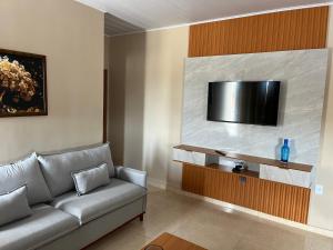 a living room with a couch and a flat screen tv at Rosendo Maia n 19 Bairro Brasiliana in Arapiraca