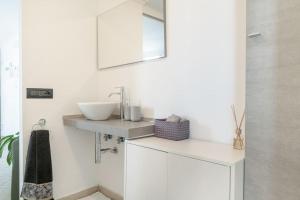 Un baño blanco con lavabo y espejo. en Residenza dell Agrifoglio, en Mostacciano 25 fotos más