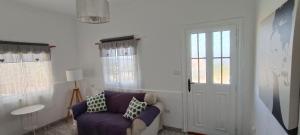 a living room with a purple couch and a window at La Estancia en La Frontera El Hierro in Frontera