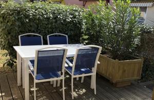 a white table with two chairs and a plant at *Jolie maison proche plage et lac marin, avec piscine, tennis à Soustons Plage* in Soustons