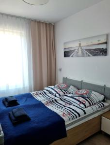a bedroom with a bed with a blue comforter at Apartament Morski - Olimpijska 2, Mielno in Mielno