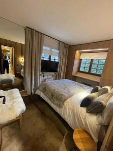 ムジェーヴにあるAppartement chaleureux à Megève - 80 m² avec jardin et cheminée.の大きなベッドと大きな窓のある寝室