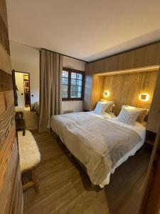 ムジェーヴにあるAppartement chaleureux à Megève - 80 m² avec jardin et cheminée.の木製のヘッドボードが付いた大きなベッドのある寝室 +5枚の写真