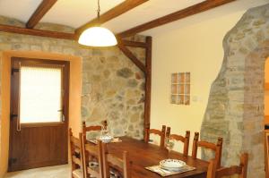 a dining room with a table and a stone wall at Giusvalla Forest Villas & Retreat, Liguria in Dego