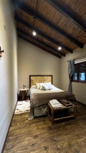 a bedroom with a large bed and a wooden ceiling at Casa Boutique con piscina y cercana a plaza de Villa de las Rosas in Villa de Las Rosas
