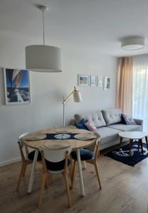 a living room with a table and a couch at Apartament Morski - Olimpijska 2, Mielno in Mielno