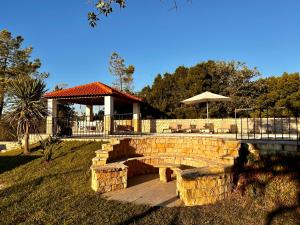 a stone bridge in a yard with a gazebo at Mountain View 2 Bedroom Chalet in Alcobaça