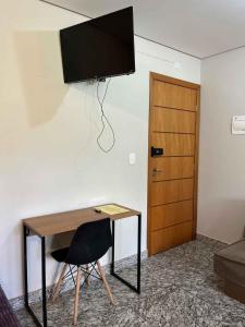 een kamer met een bureau en een televisie aan de muur bij LK Lourdes 6 in Belo Horizonte
