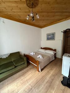 a bedroom with a bed and a couch at Amalia's House in Gjirokastër