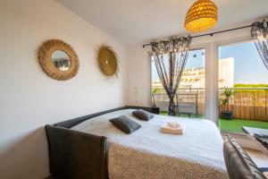 Un dormitorio con una cama grande y una ventana grande en T2 - Terrasse - 3 min à pieds des plages- Parking privée - Clim - Wifi - 4 PAX, en La Grande-Motte