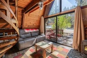 a living room with a couch and a large window at A-Frame of Mind - Nice cozy cabin great view to the outdoors and peaceful in Big Bear City