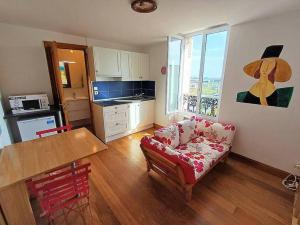 una sala de estar con un sofá y una mesa en Bonito estudio reformado 1 dormitorio 3 personas, en Hendaya