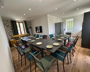 a large dining room with a long table and chairs at Le Clos de l’Olivier in Aubenas