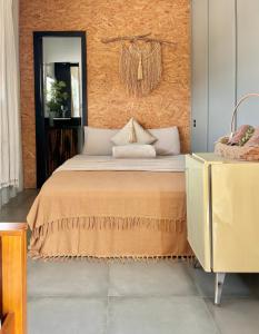 a bedroom with a bed and a mirror at Pousada Maria Parafina Praia do Rosa in Imbituba