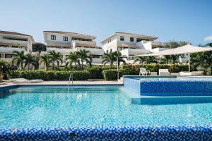 a swimming pool in front of some apartment buildings at Seabreeze Retreat Stylish Blue Bay Residence in Sint Michiel