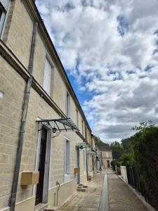 a row of buildings on a street with a cloudy sky at Chantilly Garden in Gouvieux