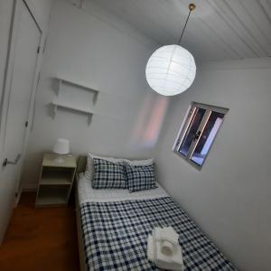 a small bedroom with a bed and a lamp at Casa da Soma in Viseu