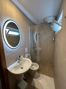 a bathroom with a sink and a toilet and a mirror at Amalia's House in Gjirokastër