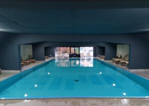 a large swimming pool with blue water in a building at Zepterme Apartman 605 Premium in Vrnjačka Banja