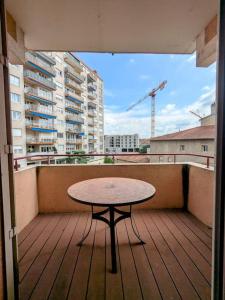 a table on a balcony with a view of a city at Bel appartement en rue piétonne in Roanne