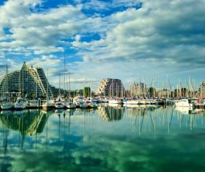 Un puerto deportivo con barcos en el agua y edificios. en T2 - Terrasse - 3 min à pieds des plages- Parking privée - Clim - Wifi - 4 PAX, en La Grande-Motte