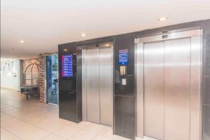 a row of elevators in a building withhazard signs at Flat terrazzo particular apto 108 in Natal