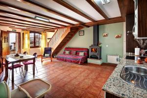a kitchen and living room with a bed and a table at Apartamentos Bellavista in Alquézar