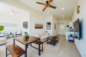 Una sala de estar con un sofá y un ventilador de techo. en Special apartment with pool in Noord Aruba, en Palm-Eagle Beach