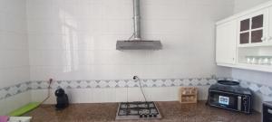 a kitchen with a stove top and a microwave at Jolie Villa vue montagne et piscine privée in Tangier