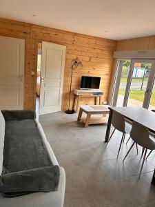 un soggiorno con un divano e un tavolo di Les balcons de la vallée de la Marne PROCHE DISNEY À Azy Sur Marne a Bonneil