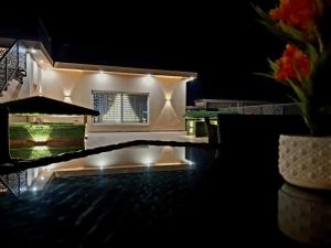 a house lit up at night with a swimming pool at Royal Galaxy Hotel & Residence - Near Islamabad International Airport & Motorway in Islamabad