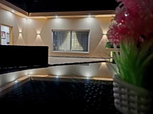 a bathroom with a sink with a window and a vase of flowers at Royal Galaxy Hotel & Residence - Near Islamabad International Airport & Motorway in Islamabad +37 photos