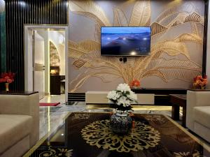 a living room with a tv on a wall at Royal Galaxy Hotel & Residence - Near Islamabad International Airport & Motorway in Islamabad
