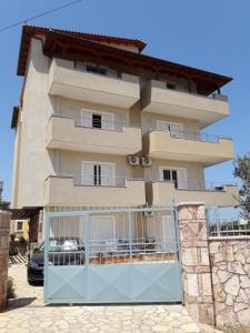 a building with a gate in front of it at Vila Oscar in Ksamil