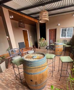 een patio met 2 wijnvaten en een tafel en stoelen bij Hotel Don Raul in Puerto Iguazú