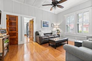 a living room with a couch and a ceiling fan at Ms. Bunny's Bungalow in Fredericksburg