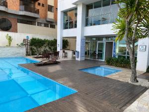 ein Schwimmbad vor einem Gebäude in der Unterkunft Condomínio MANDAI Apto 305 B Lateral em frente ao mar in Cabo Frio + 25 Fotos