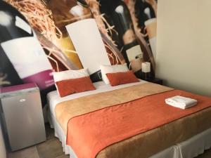 a bedroom with a bed with a painting on the wall at Edificio Terravina in Tarija