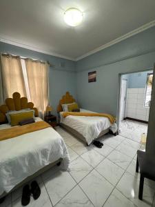 a bedroom with two beds and a tiled floor at Michu Guest house in Cape Town +46 photos
