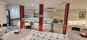 a restaurant with two tables and a counter with food at Vitoria Palace Hotel in Sinop