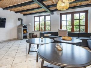 Nimtofteにある26 person holiday home in Nimtofte-By Traumの2つのテーブルと暖炉のあるリビングルーム