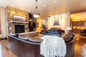 a living room with a leather couch and a fireplace at 671 Elk Circle by Summit County Mountain Retreats in Keystone