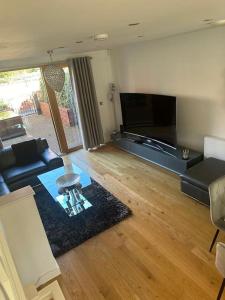 a living room with a couch and a flat screen tv at Luxury Modern Town House, Manchester City Centre, Free Secured Parking in Manchester