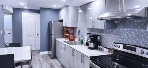 a kitchen with white cabinets and a black refrigerator at Garden Avenue Homes Free Parking in Brantford